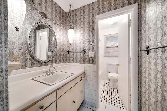 bathroom with tile patterned floors, toilet, vanity, and tile walls