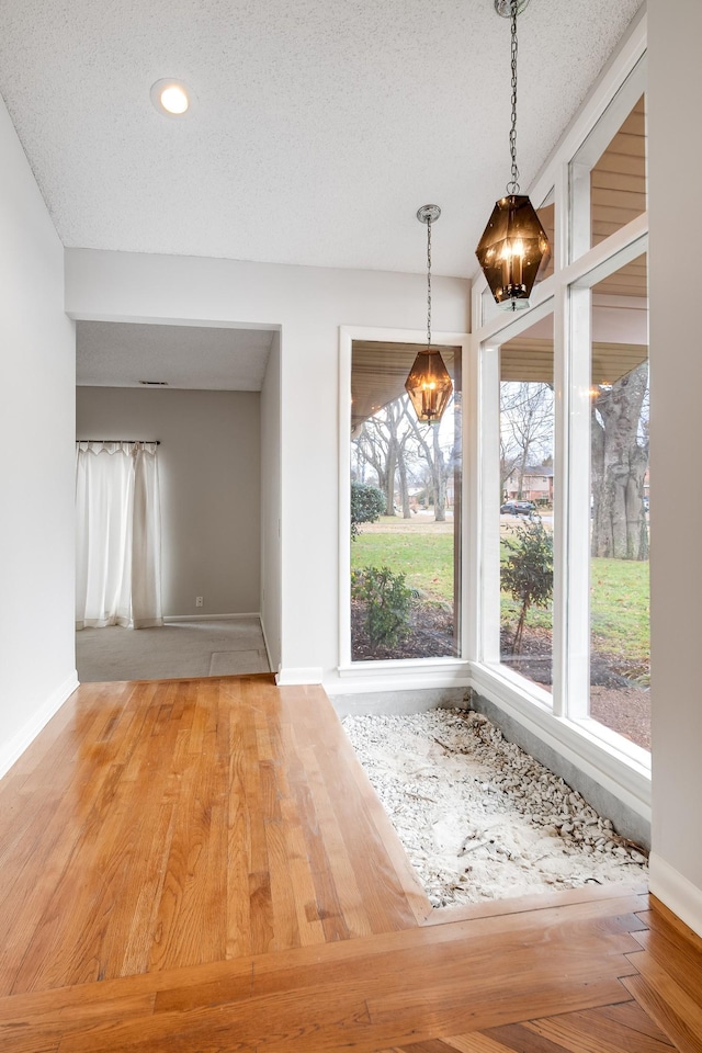 interior space featuring wood-type flooring and a textured ceiling