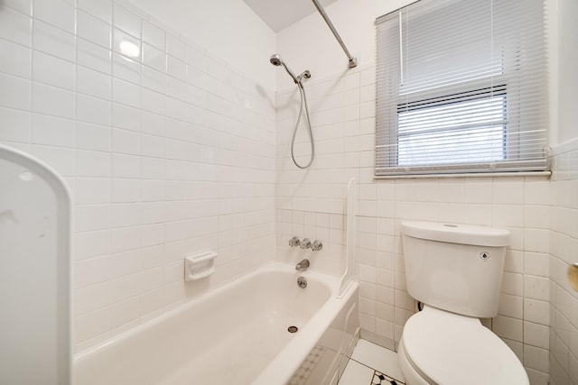 bathroom featuring tiled shower / bath combo, tile walls, and toilet