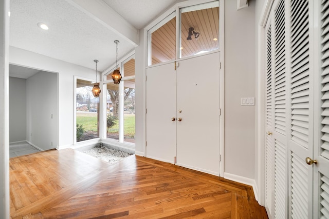 foyer entrance with wood-type flooring and a textured ceiling