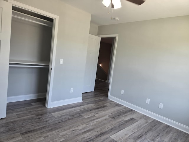 unfurnished bedroom featuring ceiling fan, dark hardwood / wood-style floors, and a closet