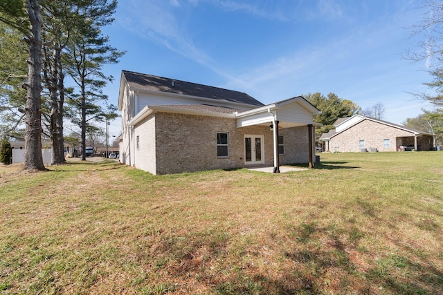 back of house featuring french doors and a lawn