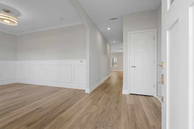 hallway featuring ornamental molding and light wood-type flooring