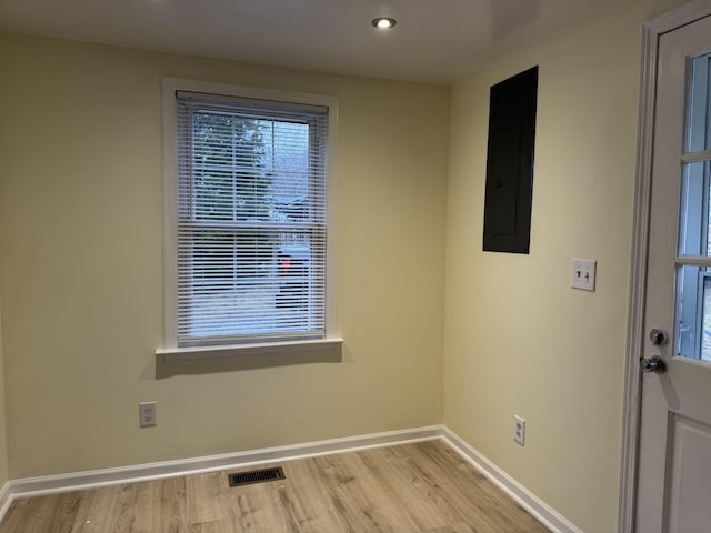 interior space with electric panel and light hardwood / wood-style floors