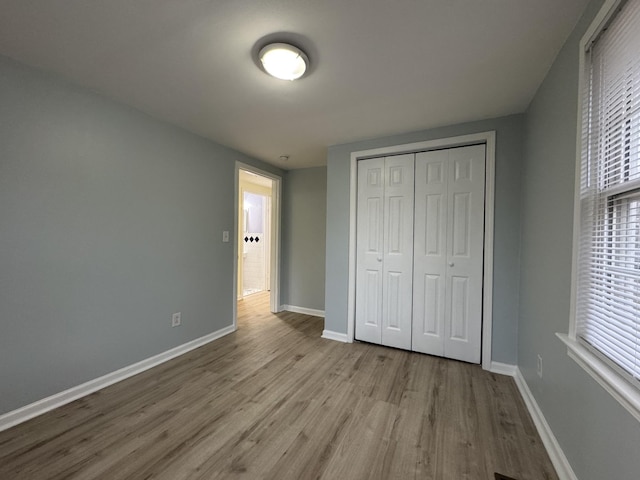 unfurnished bedroom with a closet and light hardwood / wood-style flooring