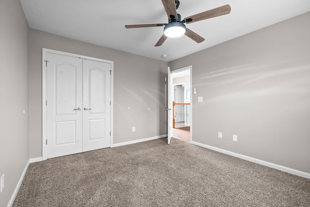 unfurnished bedroom featuring carpet flooring, ceiling fan, and a closet