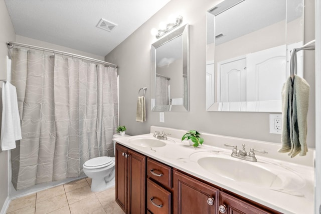 bathroom featuring tile patterned floors, toilet, and vanity