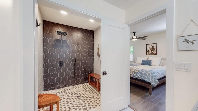 bathroom with hardwood / wood-style flooring, ceiling fan, and a tile shower