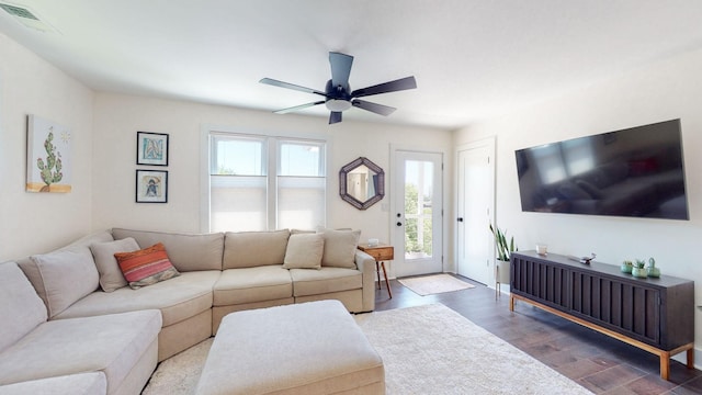 living room featuring dark wood-type flooring and ceiling fan