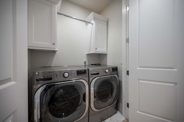 laundry room featuring cabinets and washer and clothes dryer