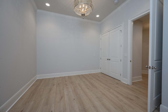 unfurnished room featuring ornamental molding, an inviting chandelier, and light hardwood / wood-style flooring