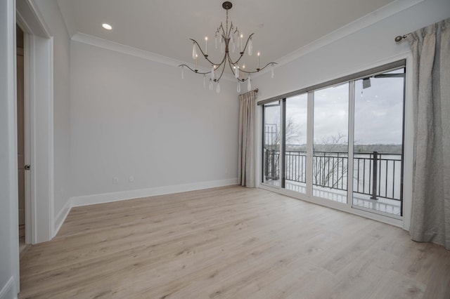 empty room featuring crown molding, a chandelier, and light hardwood / wood-style floors