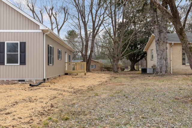 view of yard with central air condition unit and a deck