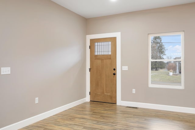 entrance foyer with light wood finished floors, visible vents, and baseboards