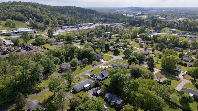drone / aerial view featuring a wooded view and a residential view