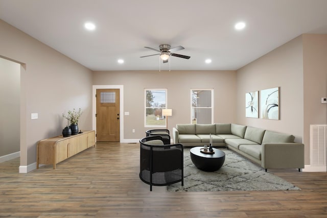 living room featuring visible vents, baseboards, ceiling fan, and wood finished floors