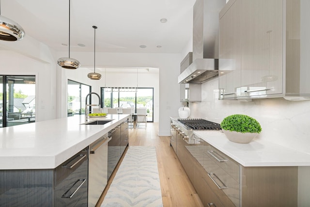 kitchen with extractor fan, tasteful backsplash, a large island with sink, hanging light fixtures, and stainless steel appliances