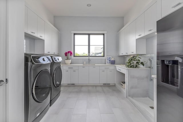 washroom featuring cabinets, sink, and independent washer and dryer