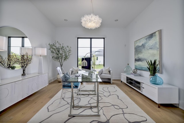 office space featuring a healthy amount of sunlight, a chandelier, and light hardwood / wood-style floors