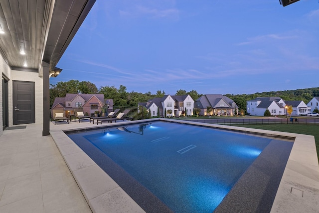 pool at dusk featuring a patio area