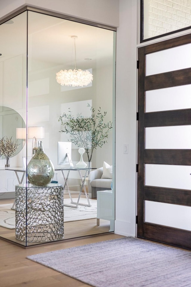 doorway to outside with a notable chandelier and hardwood / wood-style flooring