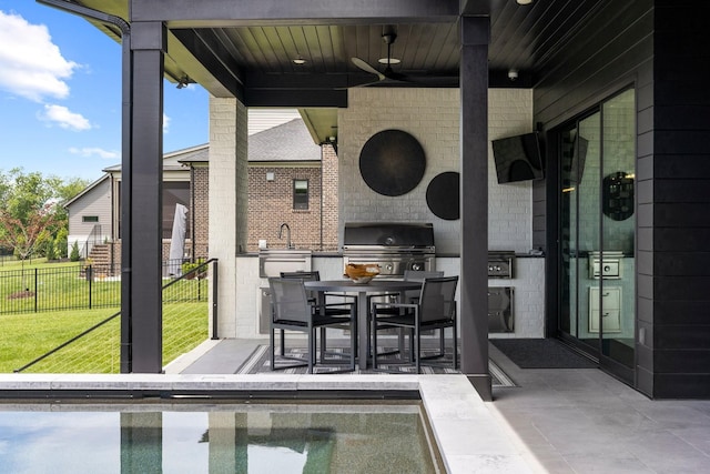 view of patio with ceiling fan, area for grilling, and grilling area