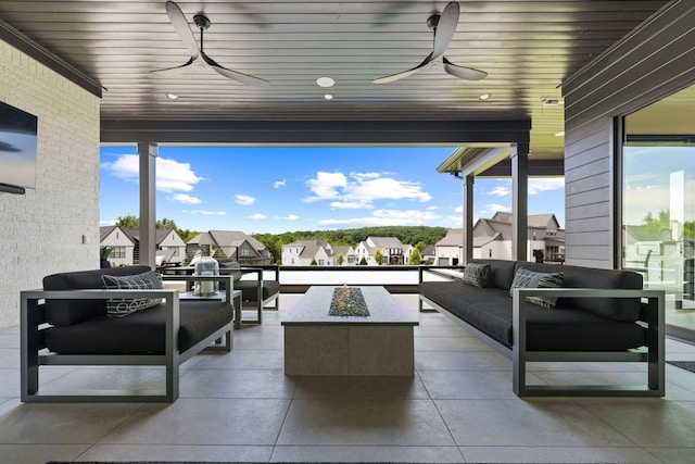 view of patio with ceiling fan and an outdoor living space with a fire pit