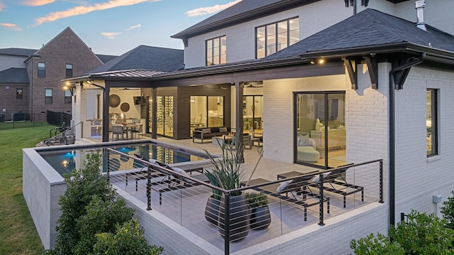 rear view of house with an outdoor living space, ceiling fan, and a patio area