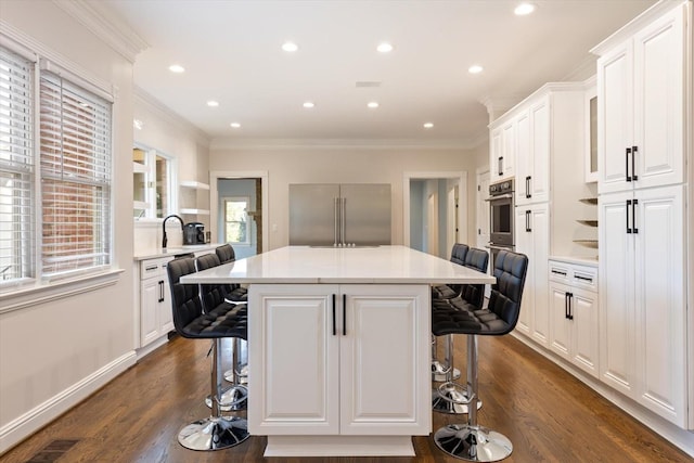 kitchen featuring appliances with stainless steel finishes, a breakfast bar area, and white cabinets