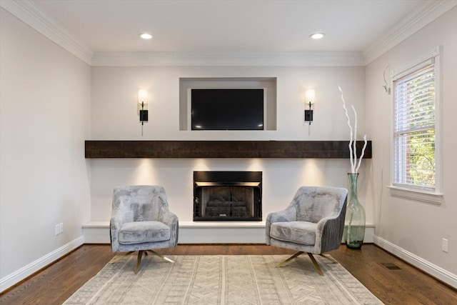 living area with wood-type flooring and ornamental molding