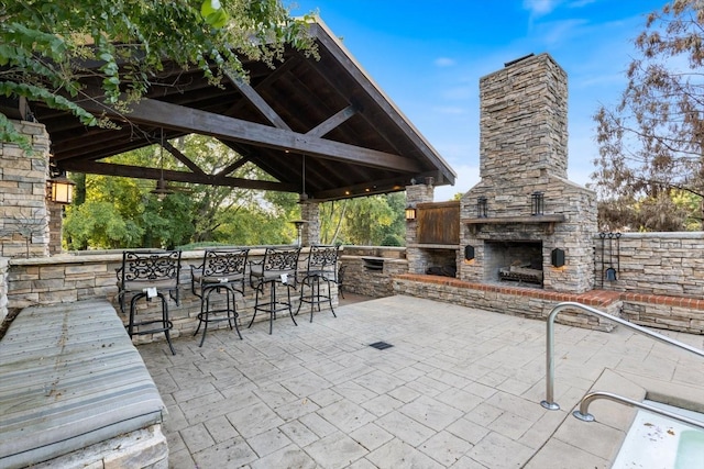 view of patio / terrace featuring a gazebo, an outdoor bar, and an outdoor stone fireplace