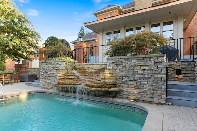 view of pool with a patio area and pool water feature