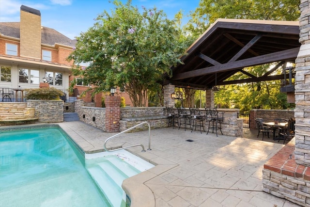 view of pool featuring a bar, a patio area, and a gazebo