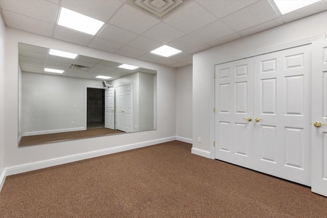 carpeted spare room featuring a paneled ceiling