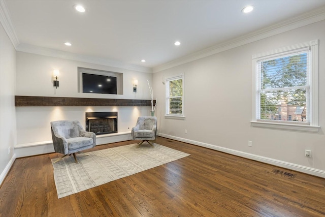 living area featuring hardwood / wood-style flooring and crown molding