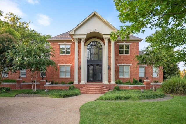 neoclassical / greek revival house featuring a front yard