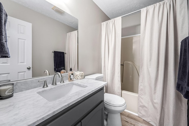 full bathroom featuring toilet, shower / tub combo, a textured ceiling, vanity, and hardwood / wood-style floors