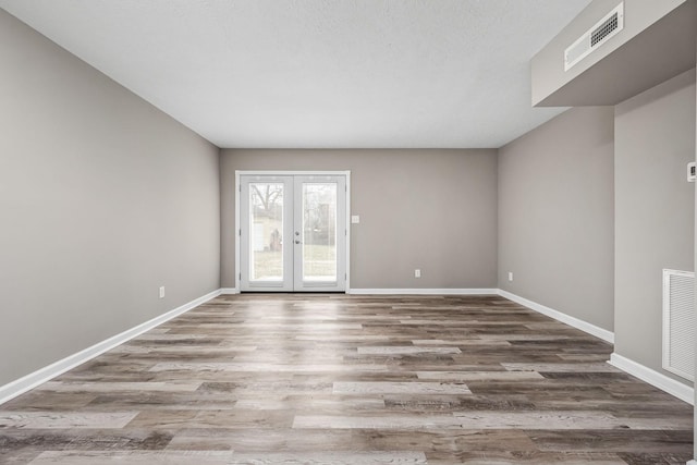 spare room featuring french doors and hardwood / wood-style floors