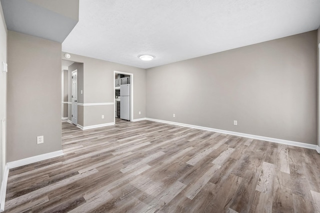 empty room featuring light hardwood / wood-style flooring and a textured ceiling