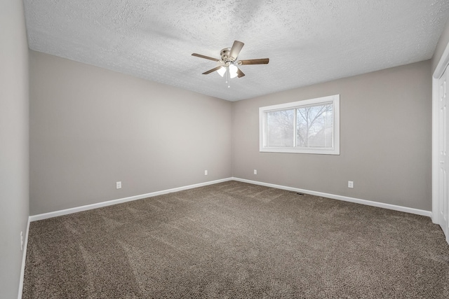 unfurnished room with ceiling fan, dark carpet, and a textured ceiling