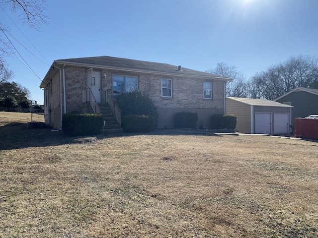 back of property featuring a garage, an outdoor structure, and a yard