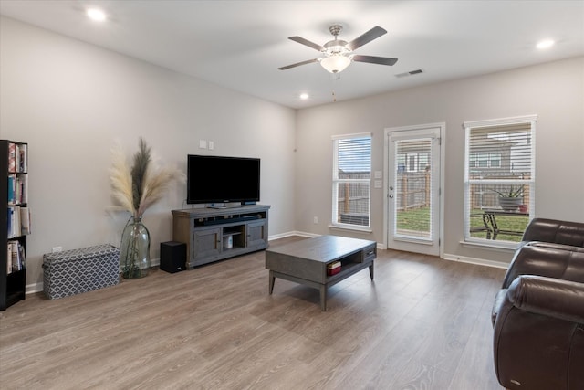 living room with ceiling fan and light hardwood / wood-style flooring