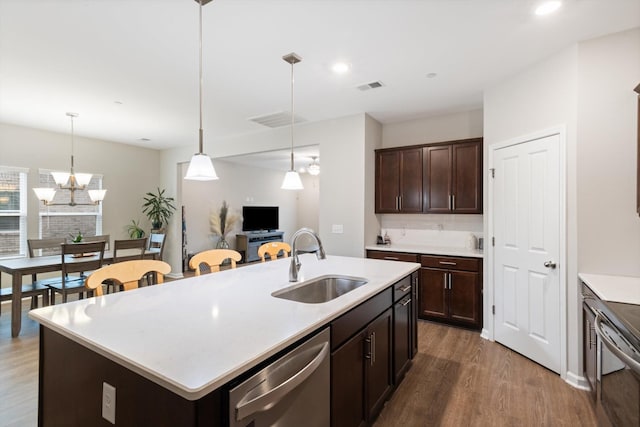 kitchen featuring dishwasher, pendant lighting, sink, and a center island with sink