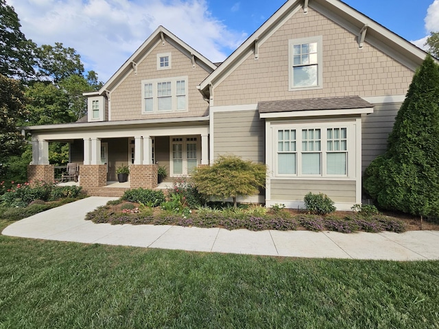 craftsman inspired home featuring a front yard and covered porch