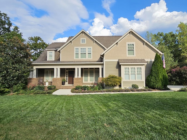 craftsman-style house featuring covered porch and a front lawn