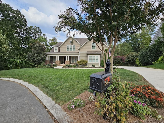 craftsman inspired home featuring a porch and a front lawn