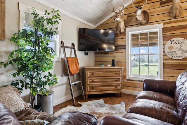 living room featuring lofted ceiling, hardwood / wood-style floors, wood ceiling, and wooden walls