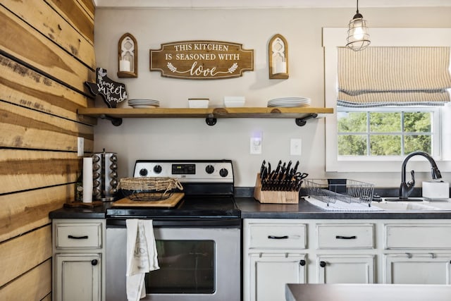 kitchen featuring hanging light fixtures, white cabinetry, sink, and electric range