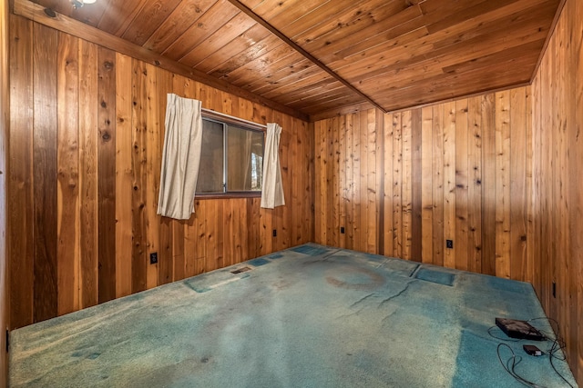 unfurnished room featuring carpet floors, wood ceiling, and wood walls