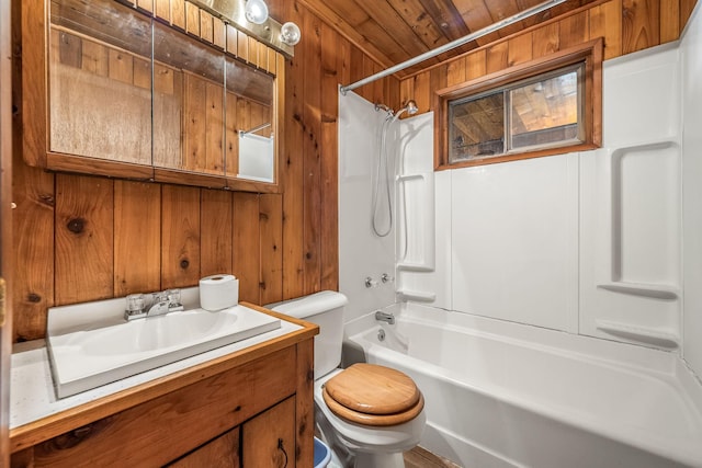 full bathroom with vanity, wooden walls, tub / shower combination, and toilet